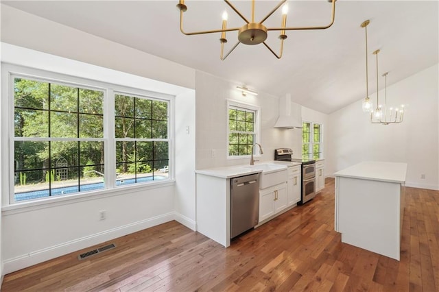 kitchen featuring sink, an inviting chandelier, white cabinetry, hanging light fixtures, and stainless steel appliances