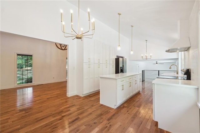 kitchen featuring a kitchen island with sink, hanging light fixtures, high vaulted ceiling, white cabinets, and stainless steel fridge with ice dispenser