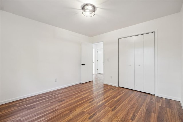 unfurnished bedroom featuring dark wood-type flooring and a closet