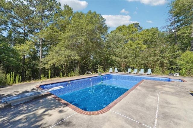 view of pool featuring a diving board and a patio area