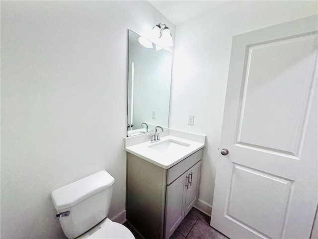 half bathroom with vanity, toilet, and tile patterned floors