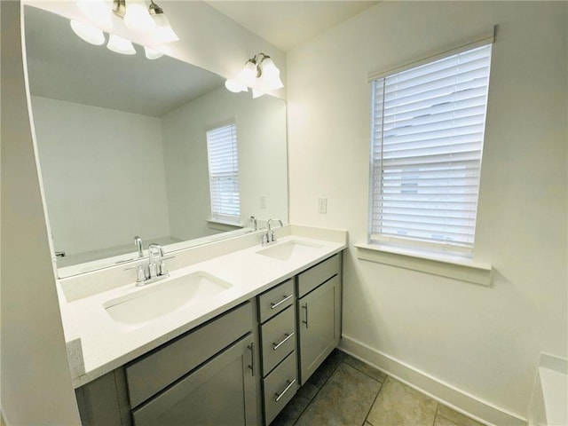 bathroom with baseboards, double vanity, and tile patterned flooring