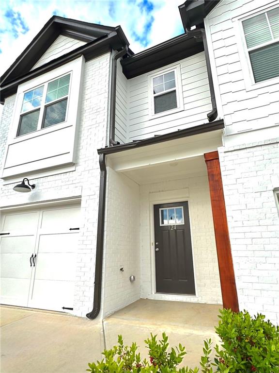 property entrance with brick siding and an attached garage