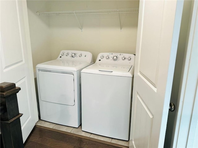 washroom with washer and clothes dryer and wood finished floors