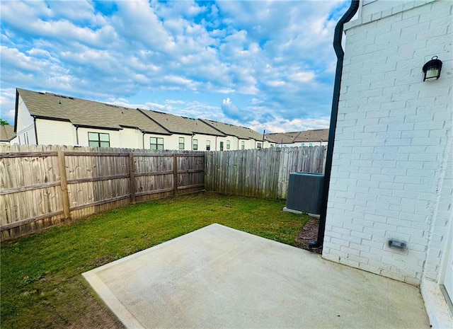 view of yard featuring a patio, a residential view, and central AC unit