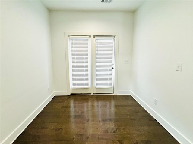 empty room with wood finished floors and baseboards
