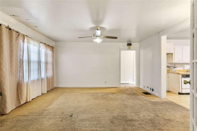 unfurnished living room with visible vents, light colored carpet, baseboards, and ceiling fan