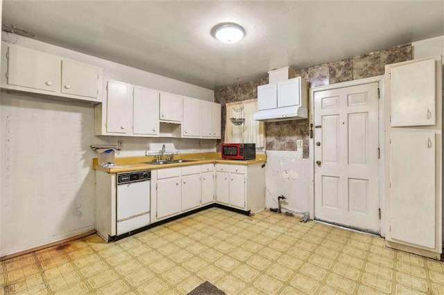 kitchen with a sink, light floors, white cabinets, and white dishwasher