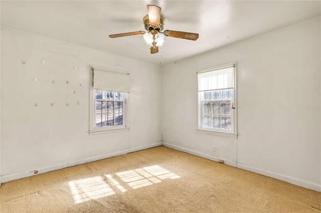 empty room featuring baseboards, carpet, a healthy amount of sunlight, and a ceiling fan