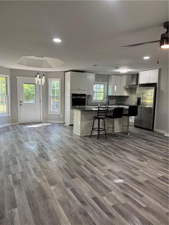 1382 Bennett Rd, Grayson, GA 30017 - kitchen with stainless steel appliances, wall chimney exhaust hood, wood finished floors, and recessed lighting