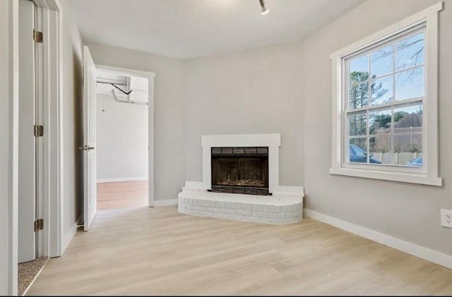 1382 Bennett Rd, Grayson, GA 30017 - unfurnished living room with light wood-type flooring, a brick fireplace, and baseboards
