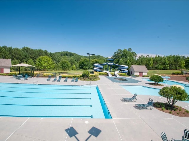 885 Lost Creek Blvd, Dallas, GA 30132 - community pool featuring a water slide, a forest view, and a patio
