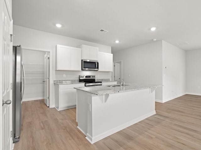 885 Lost Creek Blvd, Dallas, GA 30132 - kitchen with stainless steel appliances, light wood-style floors, white cabinets, light stone counters, and recessed lighting