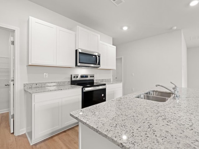 885 Lost Creek Blvd, Dallas, GA 30132 - kitchen with appliances with stainless steel finishes, light wood-style floors, white cabinets, light stone countertops, and recessed lighting