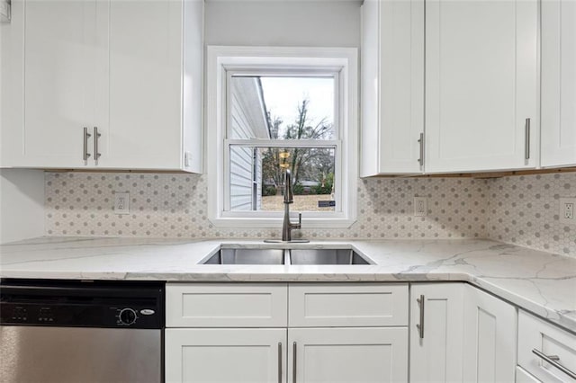 kitchen featuring decorative backsplash, white cabinets, dishwasher, light stone countertops, and a sink