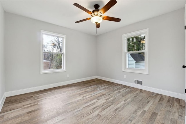 unfurnished room featuring baseboards, visible vents, light wood-style flooring, and a ceiling fan