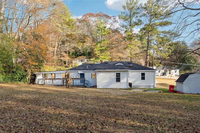 rear view of house with a storage shed, a yard, an outdoor structure, and a wooden deck