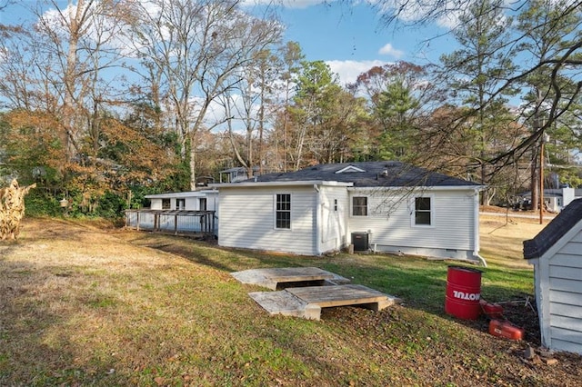 rear view of house with central AC, crawl space, and a lawn