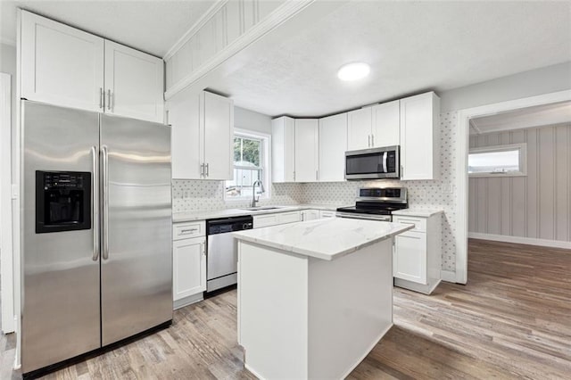 kitchen with appliances with stainless steel finishes, white cabinetry, and a sink