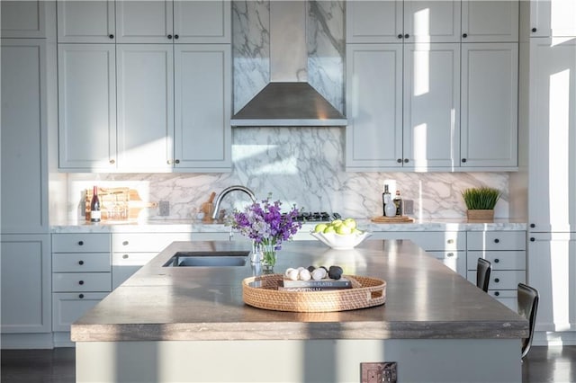 kitchen featuring wall chimney exhaust hood, sink, decorative backsplash, and gas stovetop