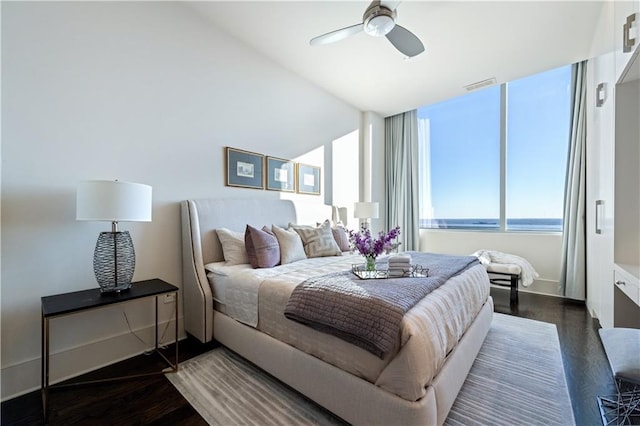 bedroom featuring a water view, ceiling fan, and dark wood-type flooring