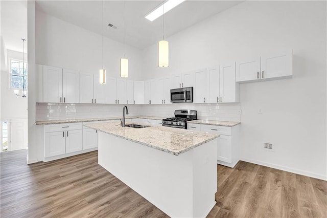 kitchen featuring appliances with stainless steel finishes, white cabinetry, and sink