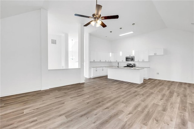 unfurnished living room featuring light hardwood / wood-style floors, vaulted ceiling, and ceiling fan