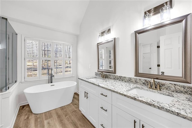 bathroom featuring a bathtub, lofted ceiling, vanity, and hardwood / wood-style floors