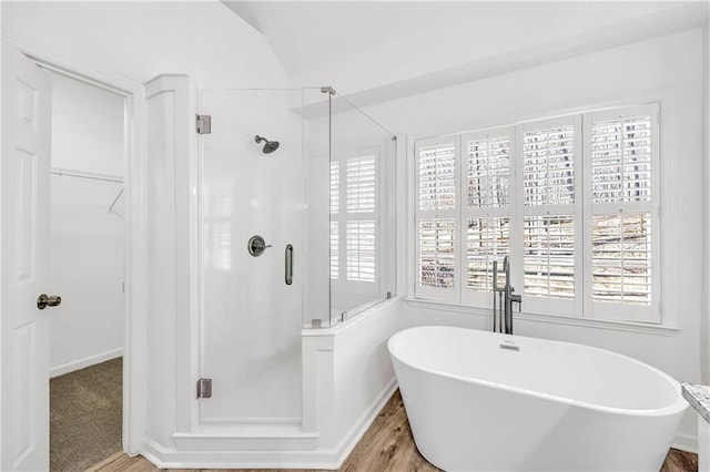 bathroom featuring plus walk in shower and hardwood / wood-style flooring