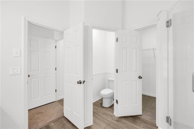 bathroom featuring wood-type flooring and toilet