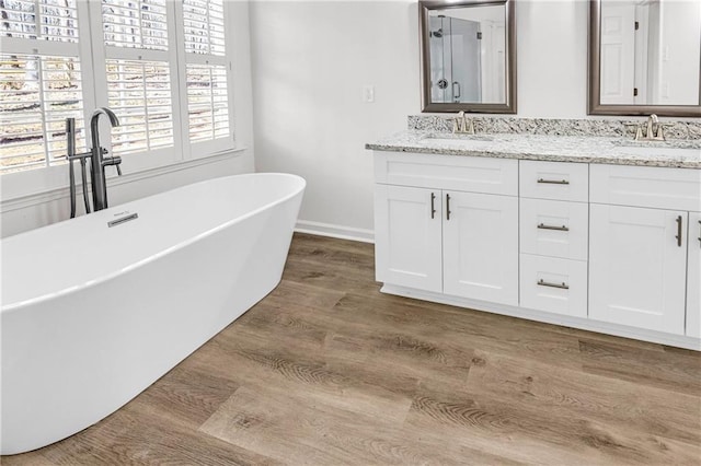 bathroom featuring independent shower and bath, hardwood / wood-style flooring, and vanity