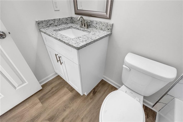 bathroom featuring vanity, hardwood / wood-style floors, and toilet