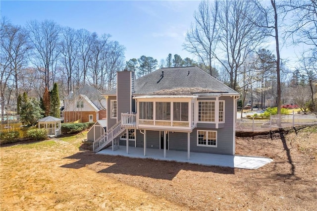 rear view of house with a patio, a gazebo, and a sunroom