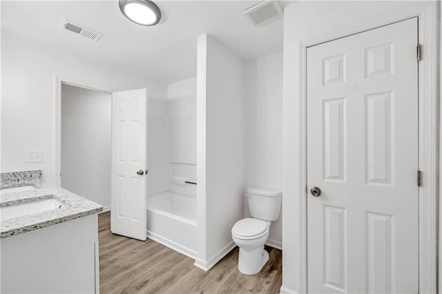 bathroom with hardwood / wood-style floors, vanity, and toilet