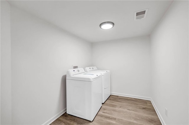 washroom featuring light hardwood / wood-style floors and washing machine and dryer