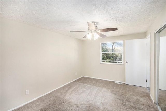 unfurnished room featuring ceiling fan, a textured ceiling, and carpet flooring