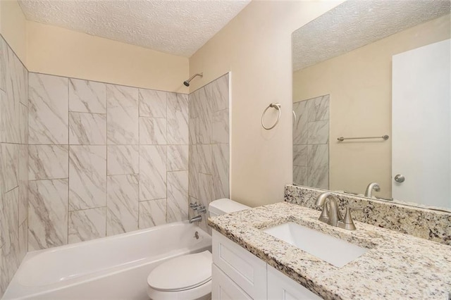 full bathroom featuring a textured ceiling, toilet, tiled shower / bath, and vanity