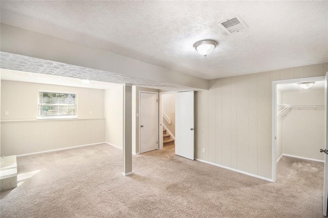 basement with light carpet and a textured ceiling