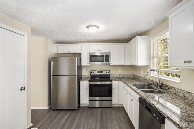 kitchen featuring light stone counters, sink, white cabinetry, and stainless steel appliances