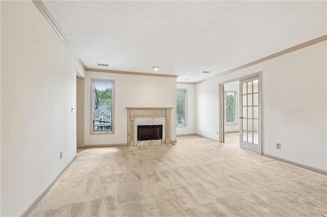unfurnished living room featuring baseboards, ornamental molding, light carpet, and a premium fireplace