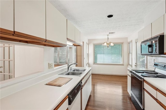 kitchen with white dishwasher, a sink, light countertops, a textured ceiling, and range with electric cooktop