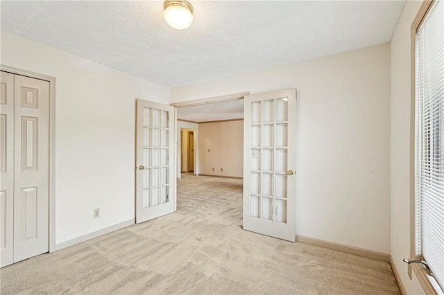 unfurnished bedroom featuring baseboards, carpet, and french doors
