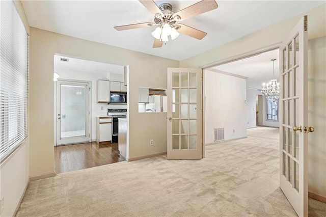 empty room featuring french doors, carpet, and visible vents