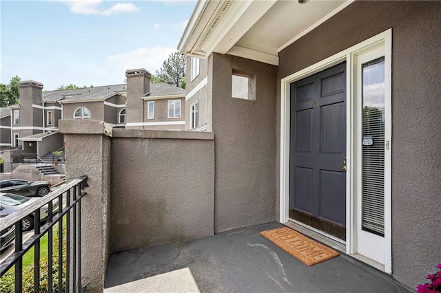 doorway to property featuring a balcony and stucco siding