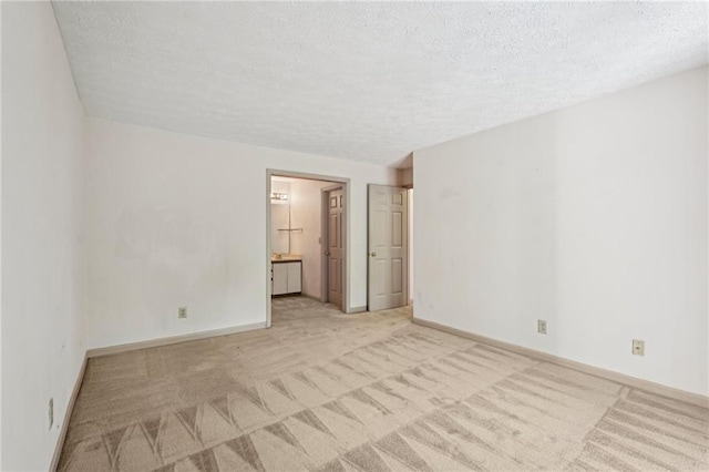 spare room with light colored carpet and a textured ceiling