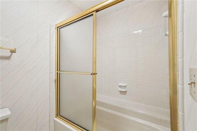 full bath featuring combined bath / shower with glass door and toilet
