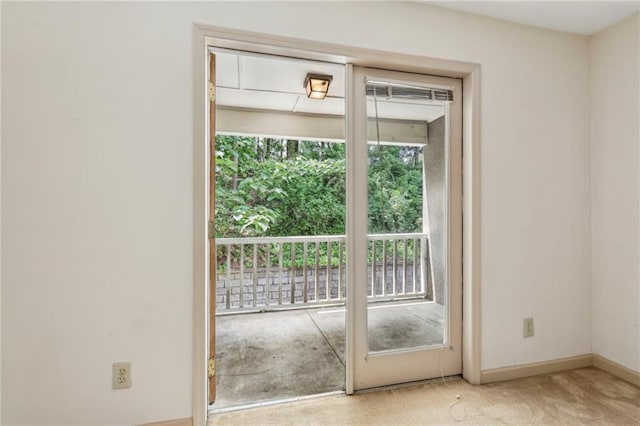 entryway with baseboards and light carpet