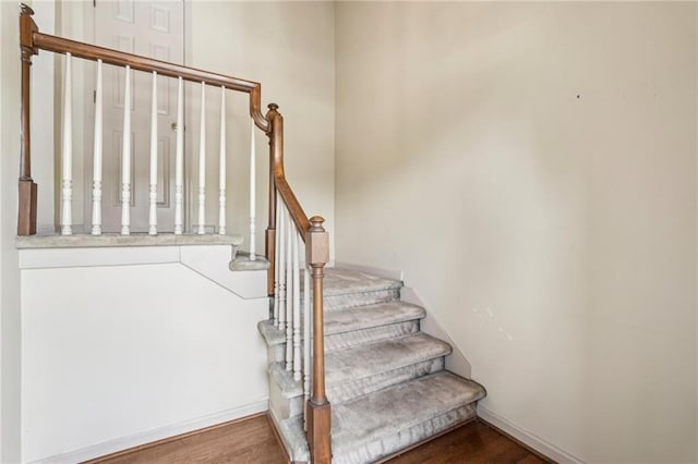 stairway with baseboards and wood finished floors
