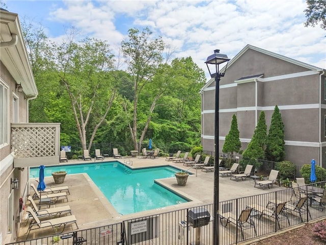 community pool with a patio and fence