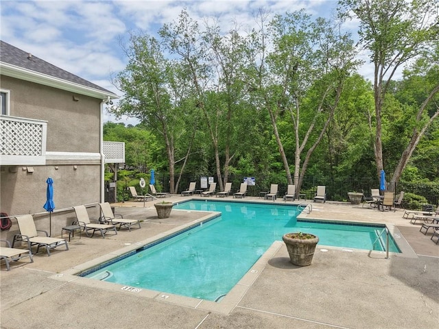 community pool with fence and a patio area
